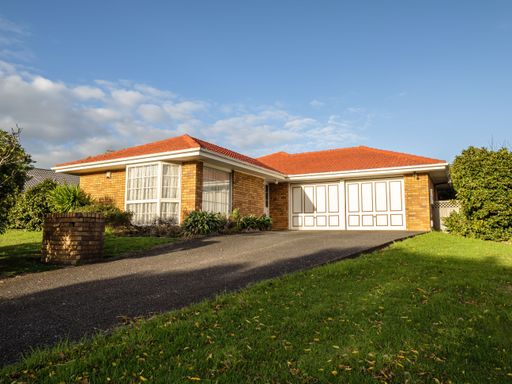 View of red brick and tile suburban house.