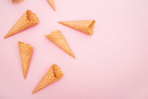 An aerial view of Ice cream waffle cones in a pink background