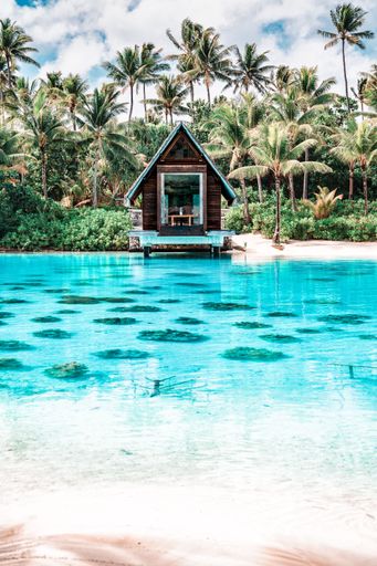 A vertical shot of a chapel near the clear blue ocean in Bora Bora