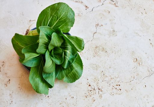 An overhead shot of a pak choi on a concrete surface with space for your text