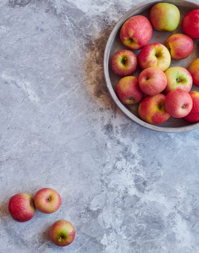 An overhead shot of fresh red apples on gray marble surface with space for your text