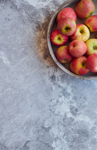 An overhead shot of fresh red apples on gray marble surface with space for your text