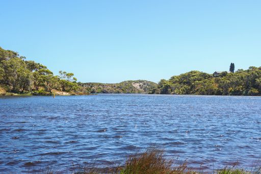 A natural view of a calm lake and mountain landscape under a clear sky