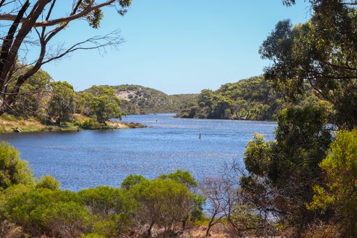 A natural view of a calm lake and mountain landscape under a clear sky