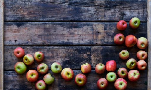 An overhead shot of fresh red apples on a wooden surface with space for your text