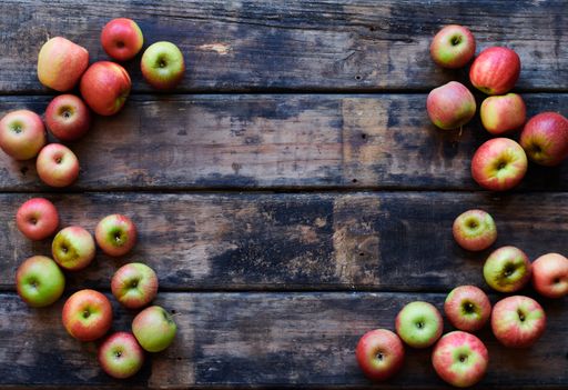 An overhead shot of fresh red apples on a wooden surface with space for your text