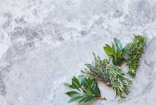An overhead shot of fresh herbs on gray marble surface with space for your text