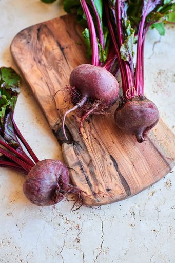 An overhead shot of fresh organic beetroot on a wooden board
