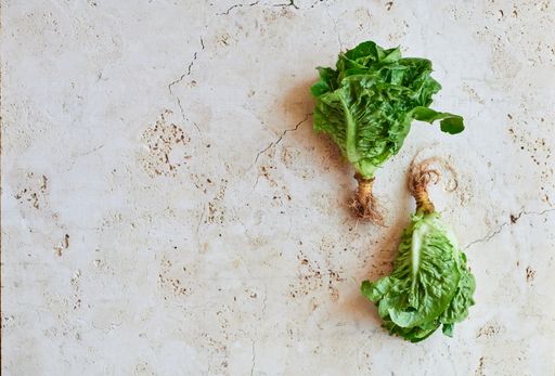 An overhead shot of fresh green lettuce on gray marble surface with space for your text