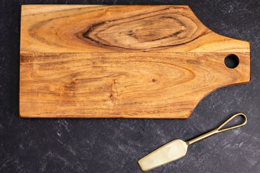 The top view of a rectangular wooden chopping board on the gray surface