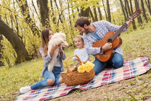 A shallow focus shot of a happy family having a picnic in a forest