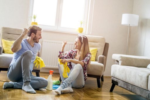 A Caucasian couple having fun while cleaning home