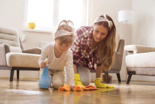 A picture of a brunette female with a kid doing a housework