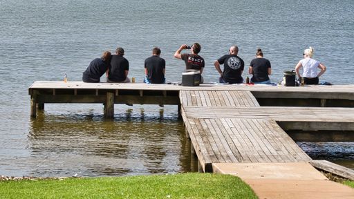A group of young people drinking and relaxing on a jetty at Lake Mulwala, New South Wales, Australia