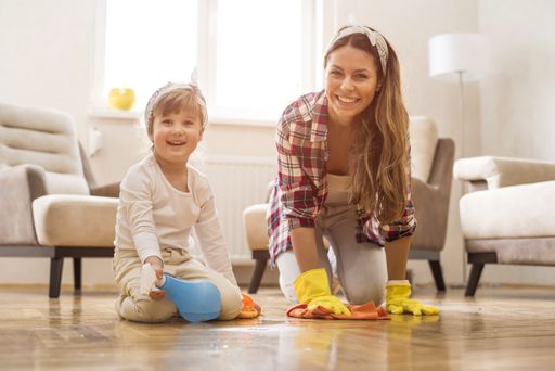 A picture of a brunette female with a kid doing a housework
