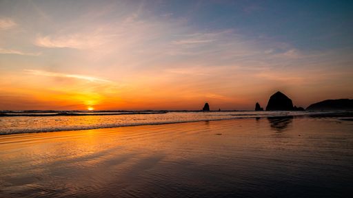 An aerial view of beautiful seascape surrounded by rocks during sunset