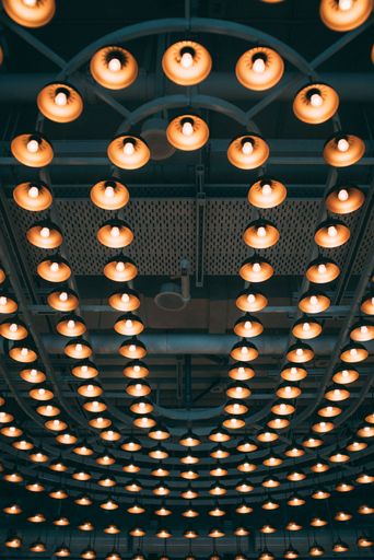 A low angle shot of a ceiling illuminated with vintage-style chandeliers