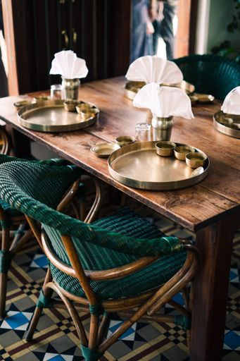 A vertical shot of the interior of a vintage hotel with a decorated wooden table and chairs in India