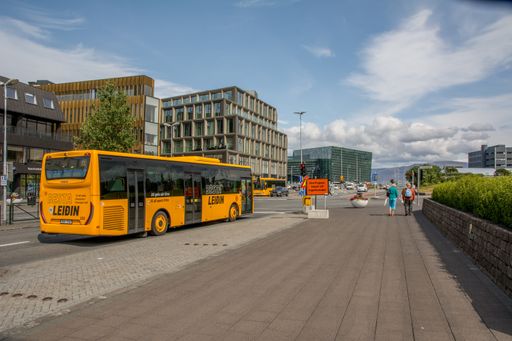 Iceland, Reykjavik, July 2019: view on the Laekjargata, Harpa museum in background, yellow Besta Leidin public transport bus in foreground