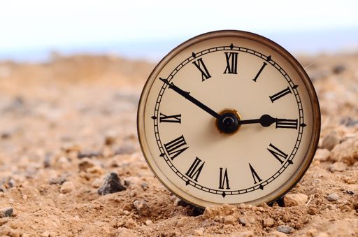 Classic Analog Clock In The Sand On The Rock Desert