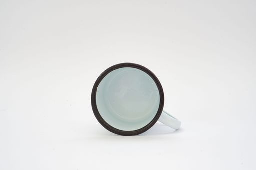 A closeup top view of a enameled cup isolated on a white background