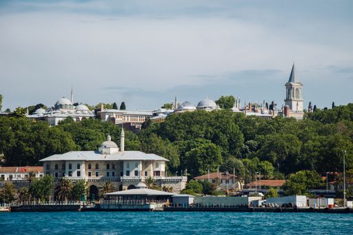 The Topkapı Palace Museum in Istanbul Turkey surrounded by trees under a cloudy sky