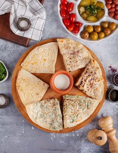 A vertical shot of tortillas with different fillings and side dishes