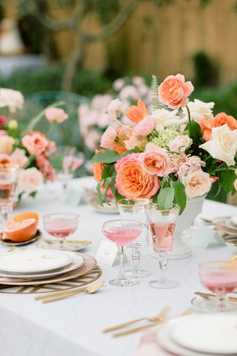 A vertical shot of an outdoor wedding table with flowers and elegant tableware