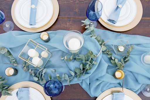 A scenic shot of a table in the wedding venue in blue and white colors