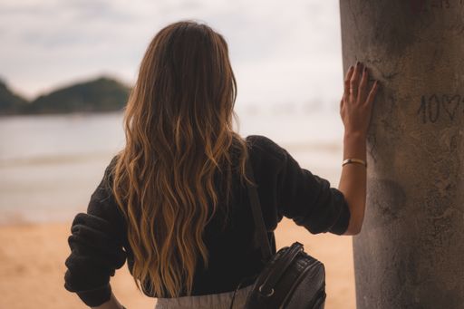 A shallow focus shot of a blonde female on her back enjoying beach view