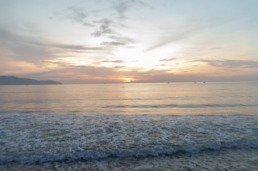A beautiful vertical shot of the sunset reflected in the sea creating a breathtaking scenery