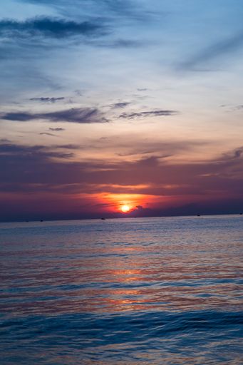 A beautiful vertical shot of the sunset reflected in the sea creating a breathtaking scenery