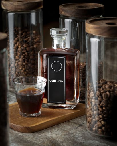 A vertical shot of a cold brew on a background of the coffee beans