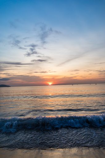 A beautiful vertical shot of the sunset reflected in the sea creating a breathtaking scenery