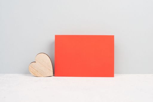 Red envelope with an empty paper, wooden heart, textured background, birthday, mothers day, fathers day and valintines day greeting card