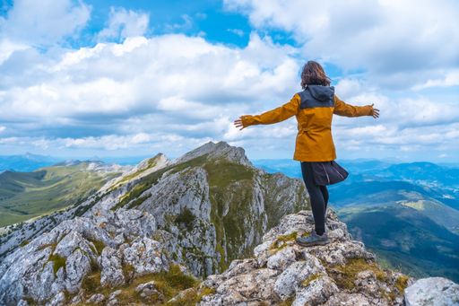 A female tourist on the top of the mount of Aitzkorri in Gipuzkoa - the concept of victory
