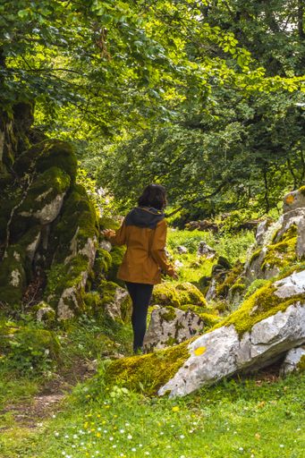 A vertical shot of a female tourist in the forest on the top of the mount of Aitzkorri in Gipuzkoa