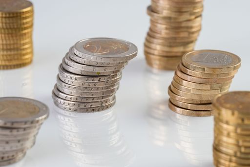 A closeup shot of piles of coins isolated on a white background