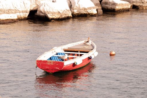 A scenic view of two seagulls perched on an old empty boat in the water in Naples, Italy
