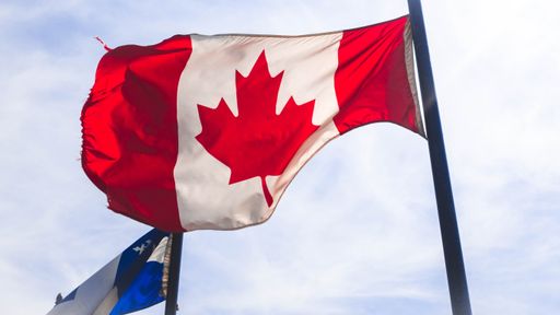 A horizontal closeup of the national flag of Canada waving with the flag of Quebec in the back. Perfect for depicting Canada.