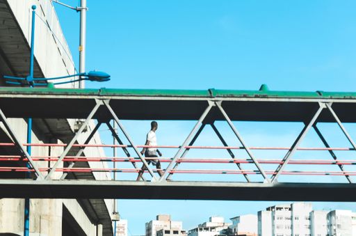 A low angle shot of a person walking on a walkway against a blue sky in Salvador city, Bahia, Brazil