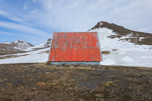 A red cabin in a mountainous environment with glacier in Snaefellsnes, Iceland