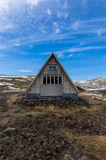 A vertical shot of a wooden cabin in a glacier field on Snaefellsnes Peninsula, Iceland