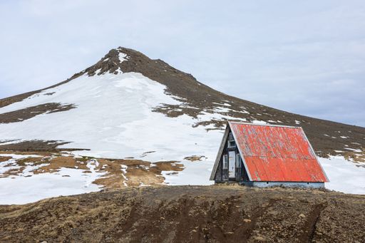 A red cabin in a mountainous environment with glacier in Snaefellsnes, Iceland