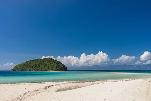 The beautiful view of the green island against the blue sky. Bon Bon Beach, Romblon, Philippines.