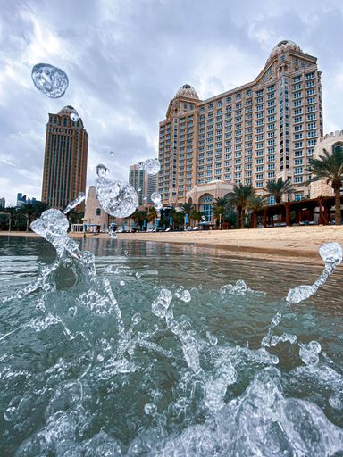 A vertical iPhone shot of water splashing on the shore of the Four Seasons Hotel in Doha, Qatar