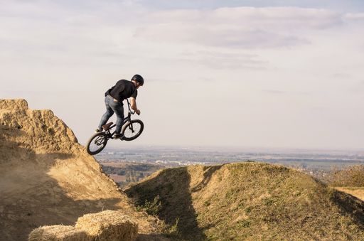 A biker jumping and flying over a hill