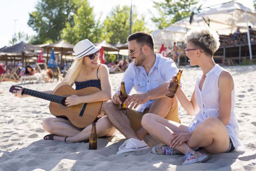 A group of Caucasian friends having fun on a sandy beach