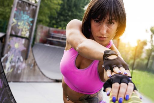 A shallow focus closeup shot of a young Caucasian female in sportswear working out in a park