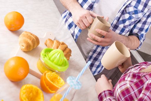 A closeup shot of a young couple preparing fresh orange juice in the kitchen